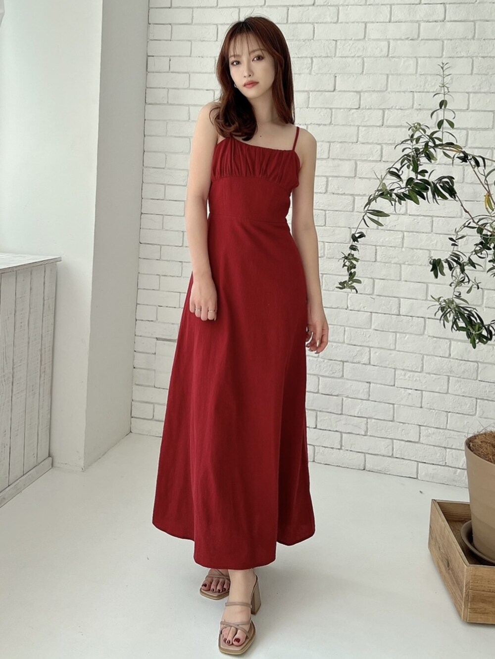 ピンク系のサンダル、レッド系のワンピースを着用したレディースの春コーディネートの3枚目の写真