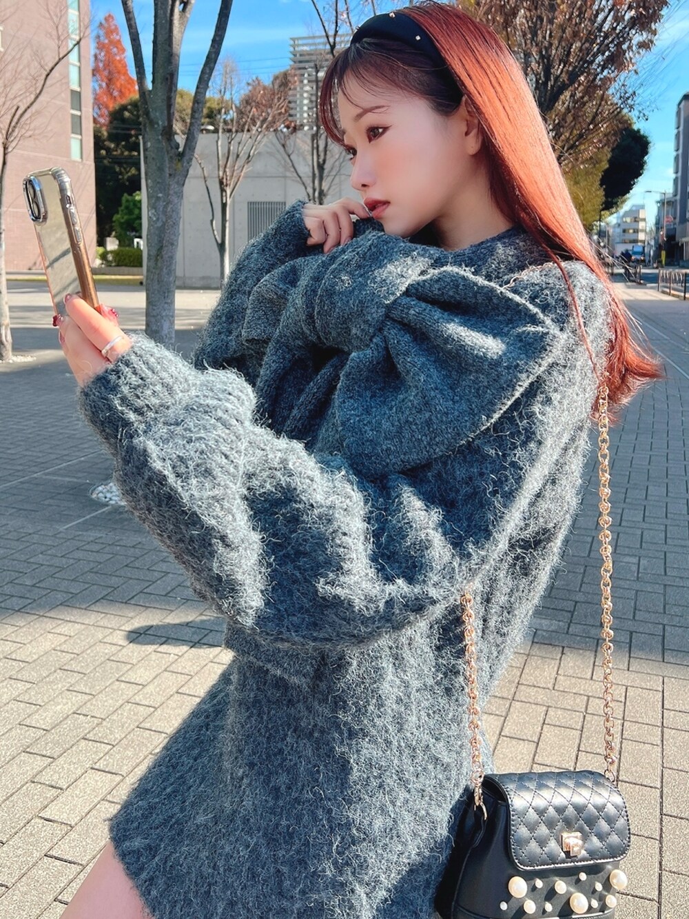 グレー系のワンピース、ブラック系のショルダーバッグを着用したレディースの冬コーディネートの3枚目の写真