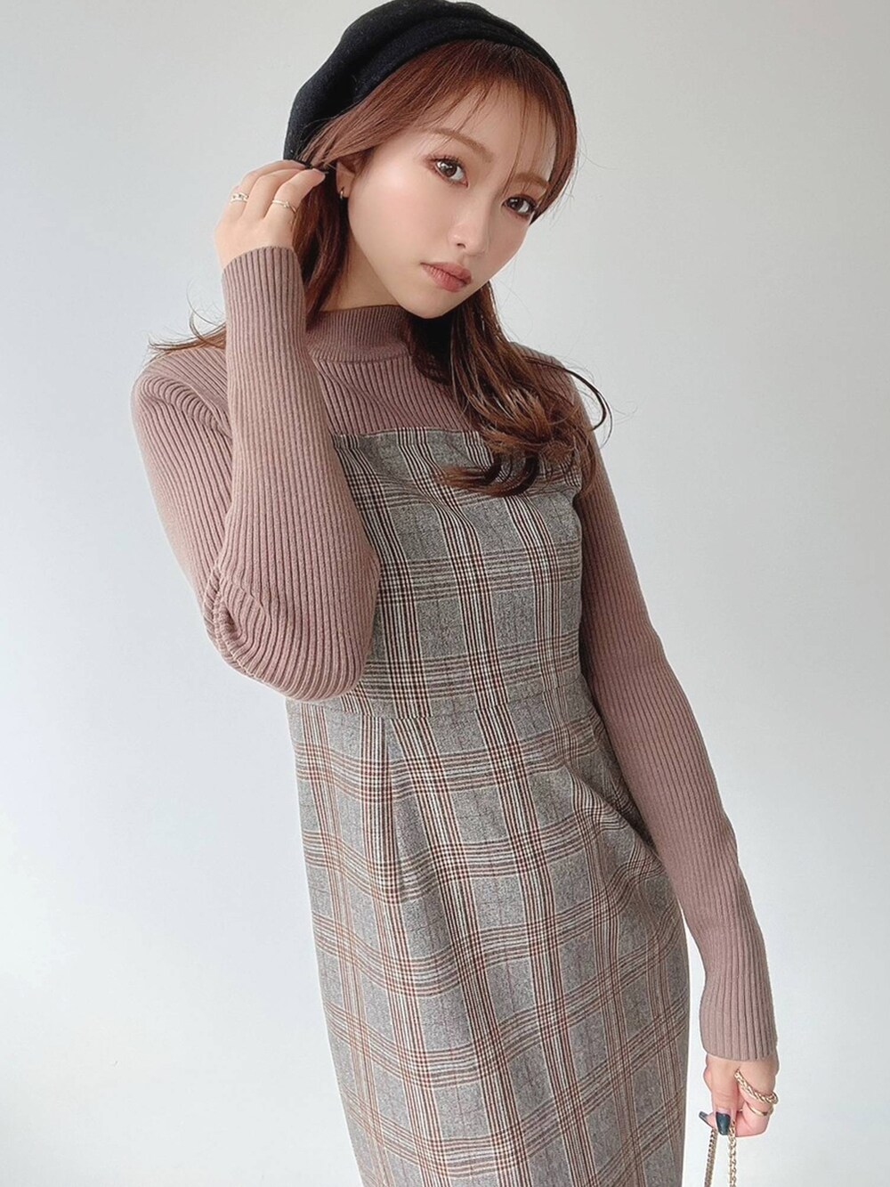 ブラウン系のワンピース、ブラック系のハンドバッグを着用したレディースの冬コーディネートの2枚目の写真