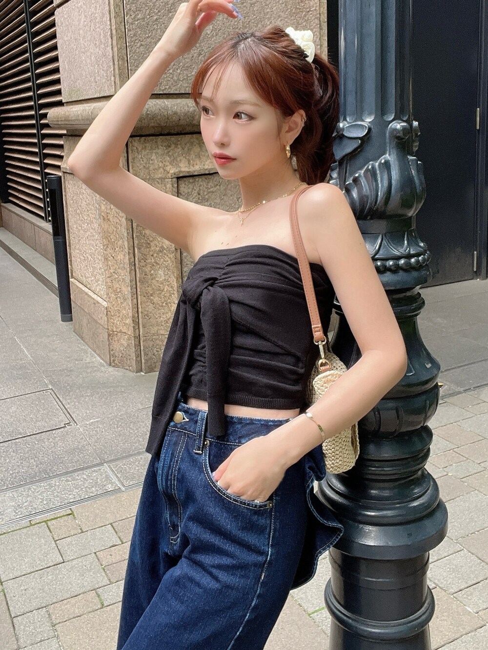 ブラック系のキャミソール、ブルー系のデニムパンツ、ベージュ系のハンドバッグを着用したレディースの夏コーディネートの2枚目の写真