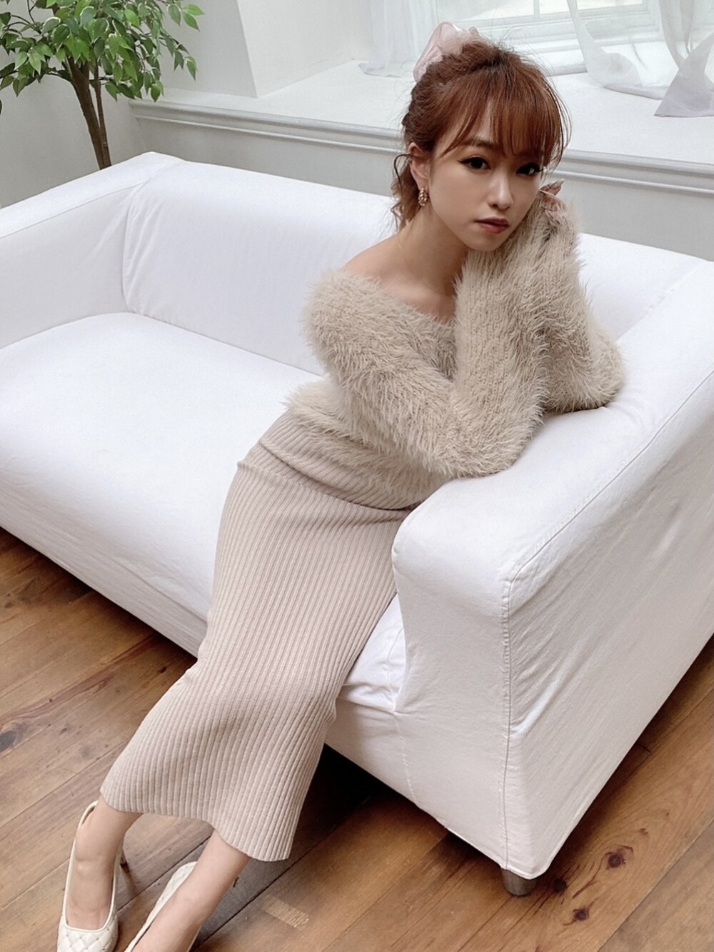 ベージュ系のワンピース、ホワイト系のパンプス、ピンク系のシュシュを着用したレディースの夏コーディネートの2枚目の写真