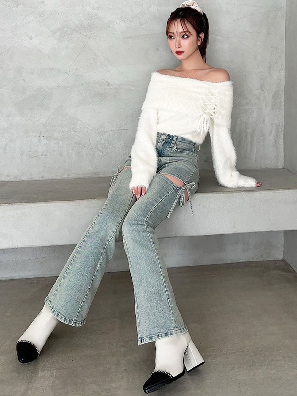 ブルー系のデニムパンツ、ホワイト系のニット/セーターを着用したレディースの秋コーディネートの2枚目の写真