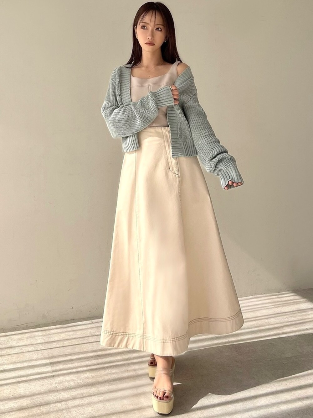 ブルー系のカーディガン/ボレロ、ベージュ系のスウェット、ホワイト系のスカートを着用したレディースの春コーディネートの2枚目の写真