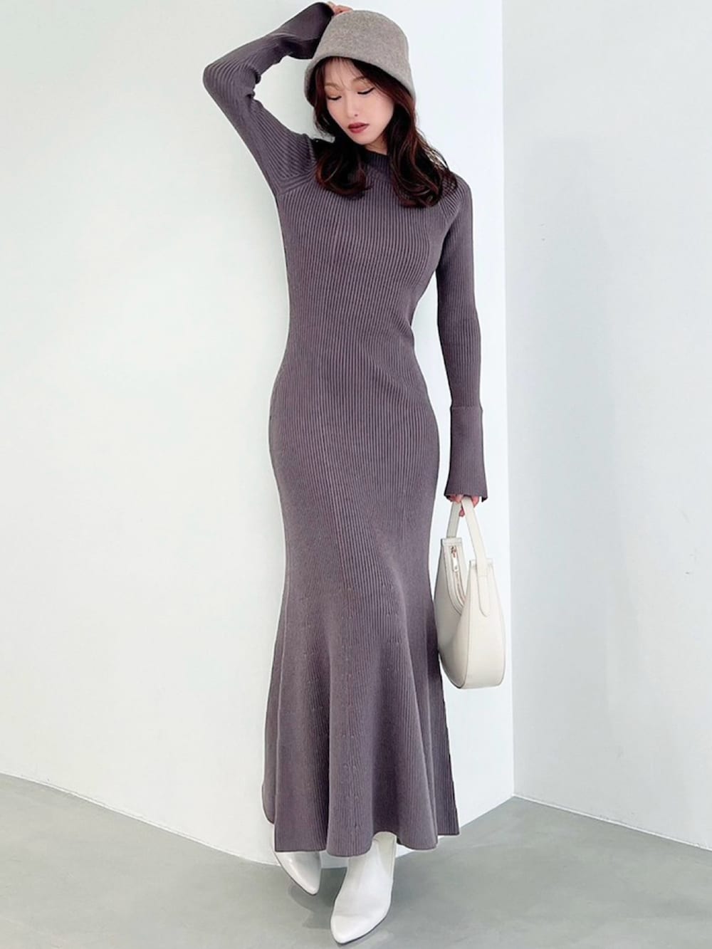 グレー系のワンピース、ホワイト系のブーツ、ホワイト系のハンドバッグを着用したレディースの秋コーディネートの3枚目の写真