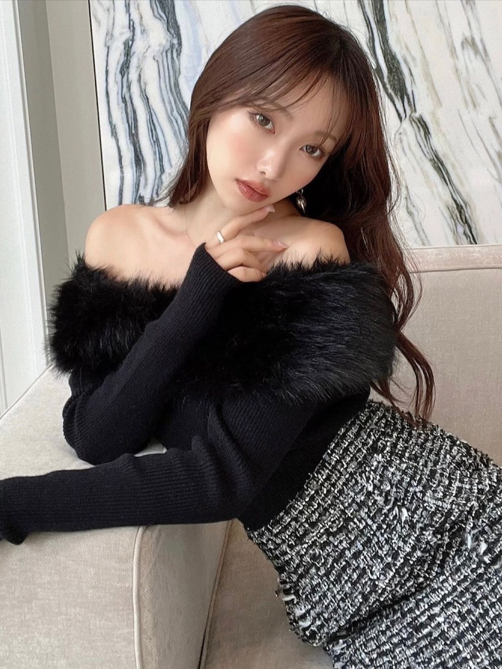 ブラック系のニット/セーター、ブラック系のパンプス、ゴールド系のピアス（両耳用）を着用したレディースの秋コーディネートの2枚目の写真