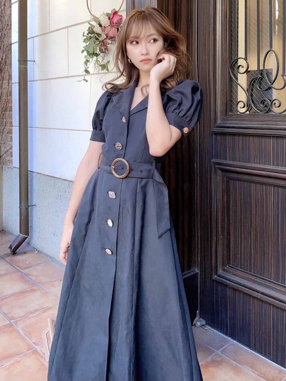 ブラック系のワンピース、ブラック系のパンプス、ブラウン系のショルダーバッグを着用したレディースの冬コーディネートの3枚目の写真