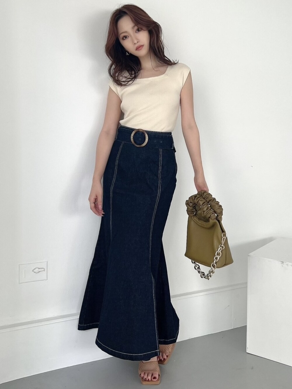 ブルー系のスカート、ホワイト系のニット/セーター、その他のサンダルを着用したレディースの夏コーディネートの2枚目の写真