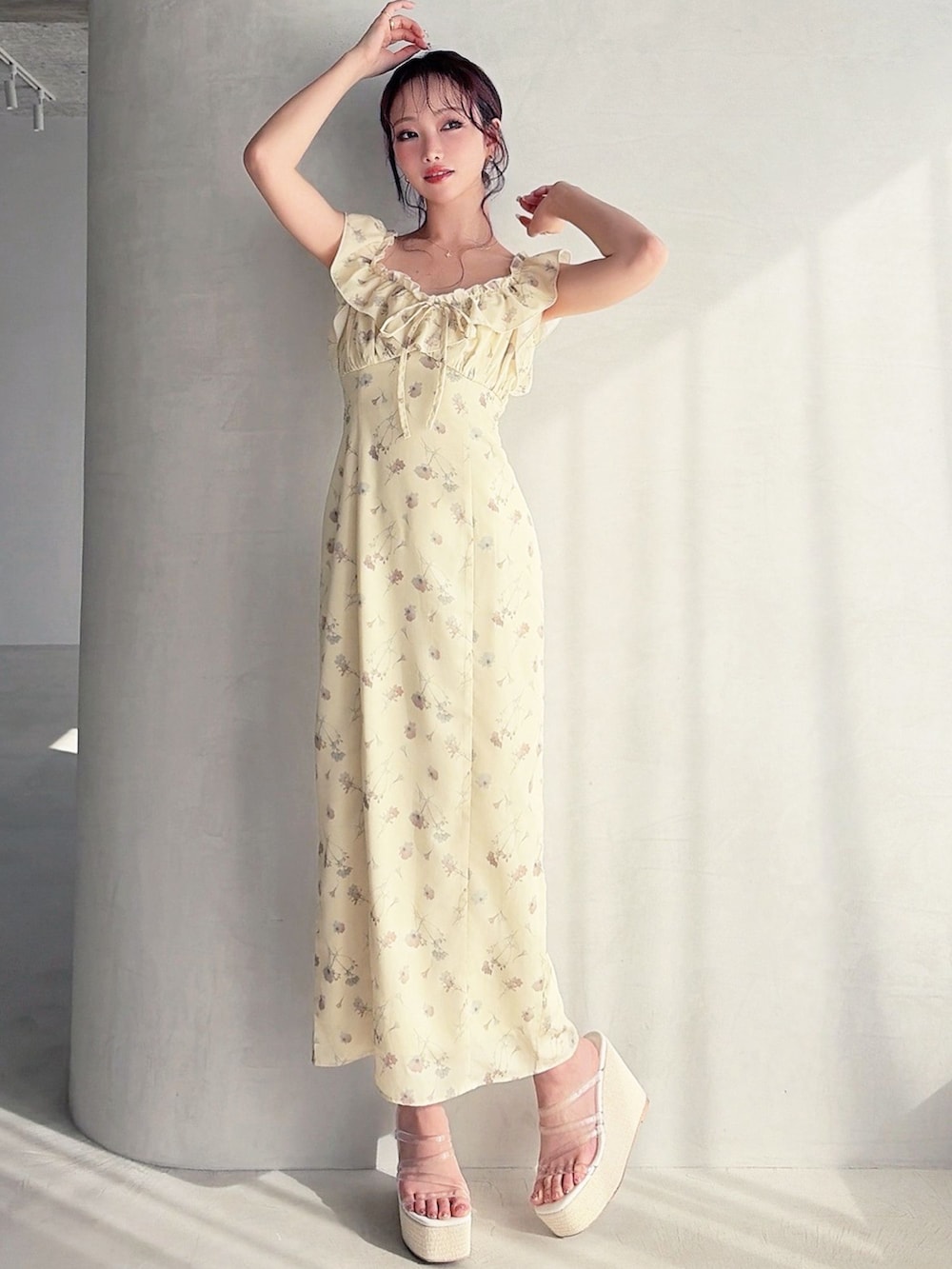 イエロー系のワンピース、ホワイト系のサンダルを着用したレディースの春コーディネートの2枚目の写真