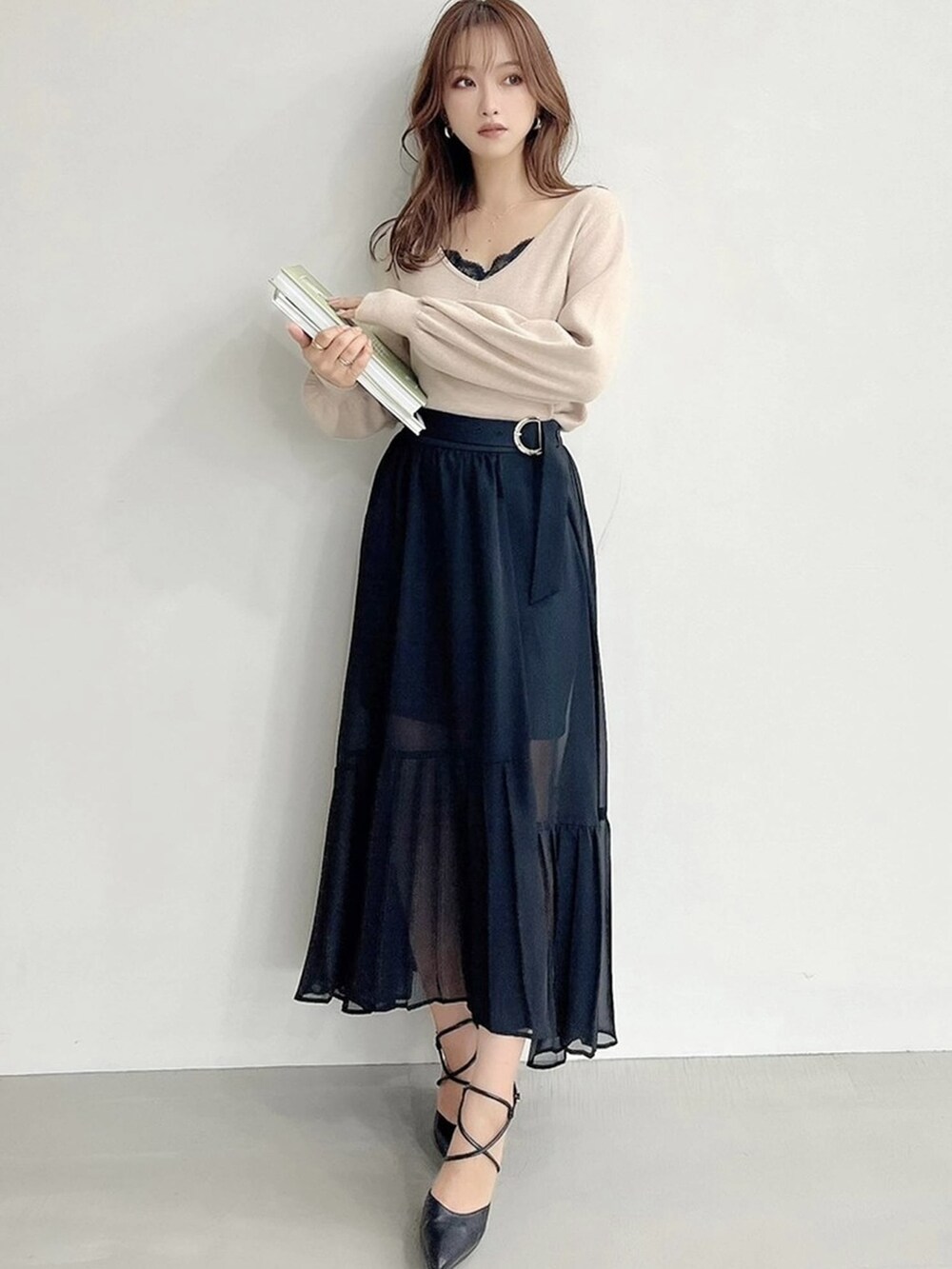 ブラック系のパンプス、ブラック系のスカート、ベージュ系のニット/セーターを着用したレディースの秋コーディネートの5枚目の写真