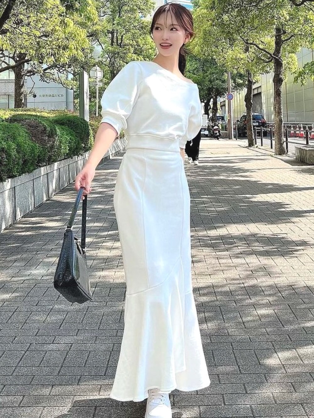 ホワイト系のスカート、ホワイト系のスウェットを着用したレディースの春コーディネートの3枚目の写真