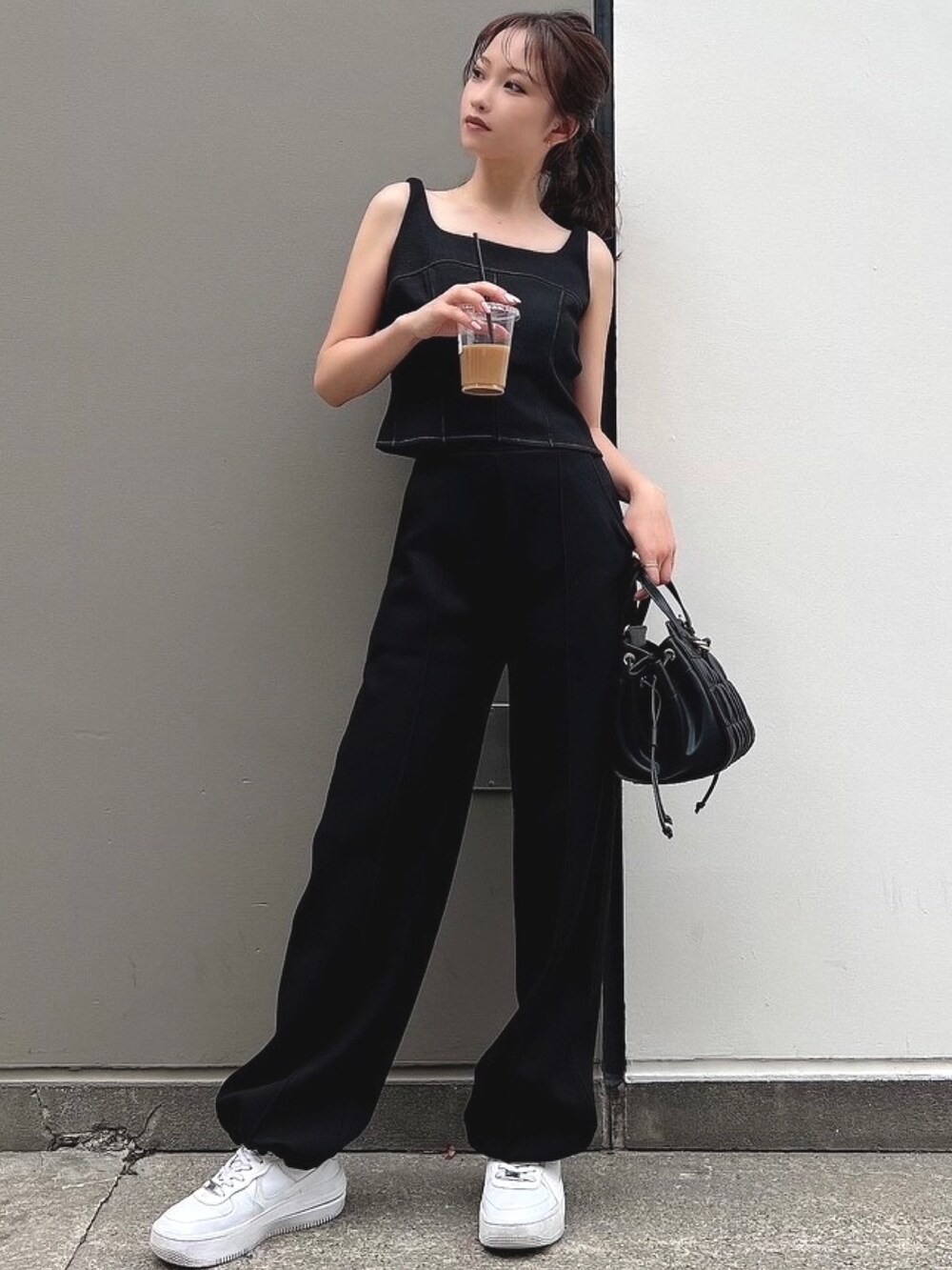 ブラック系のスウェット、ブラック系のスウェットパンツ、ブラック系のハンドバッグを着用したレディースの夏コーディネートの3枚目の写真