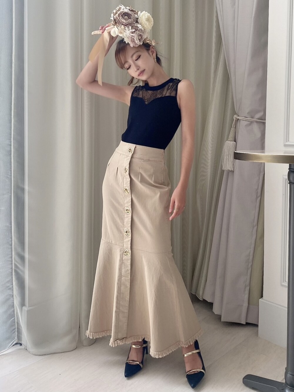 ブラック系のサンダル、ブラック系のニット/セーター、ベージュ系のスカートを着用したレディースの夏コーディネートの4枚目の写真