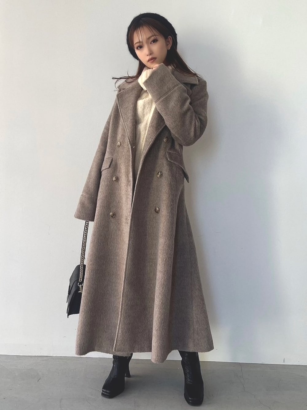 ホワイト系のニット/セーター、ブラック系のブーツ、ベージュ系のその他アウターを着用したレディースの秋コーディネートの3枚目の写真