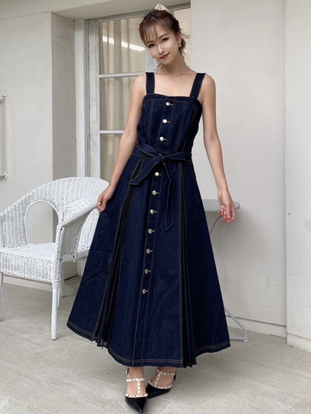 ブラック系のパンプス、ブルー系のジャンパースカート、ピンク系のシュシュを着用したレディースの夏コーディネートの4枚目の写真