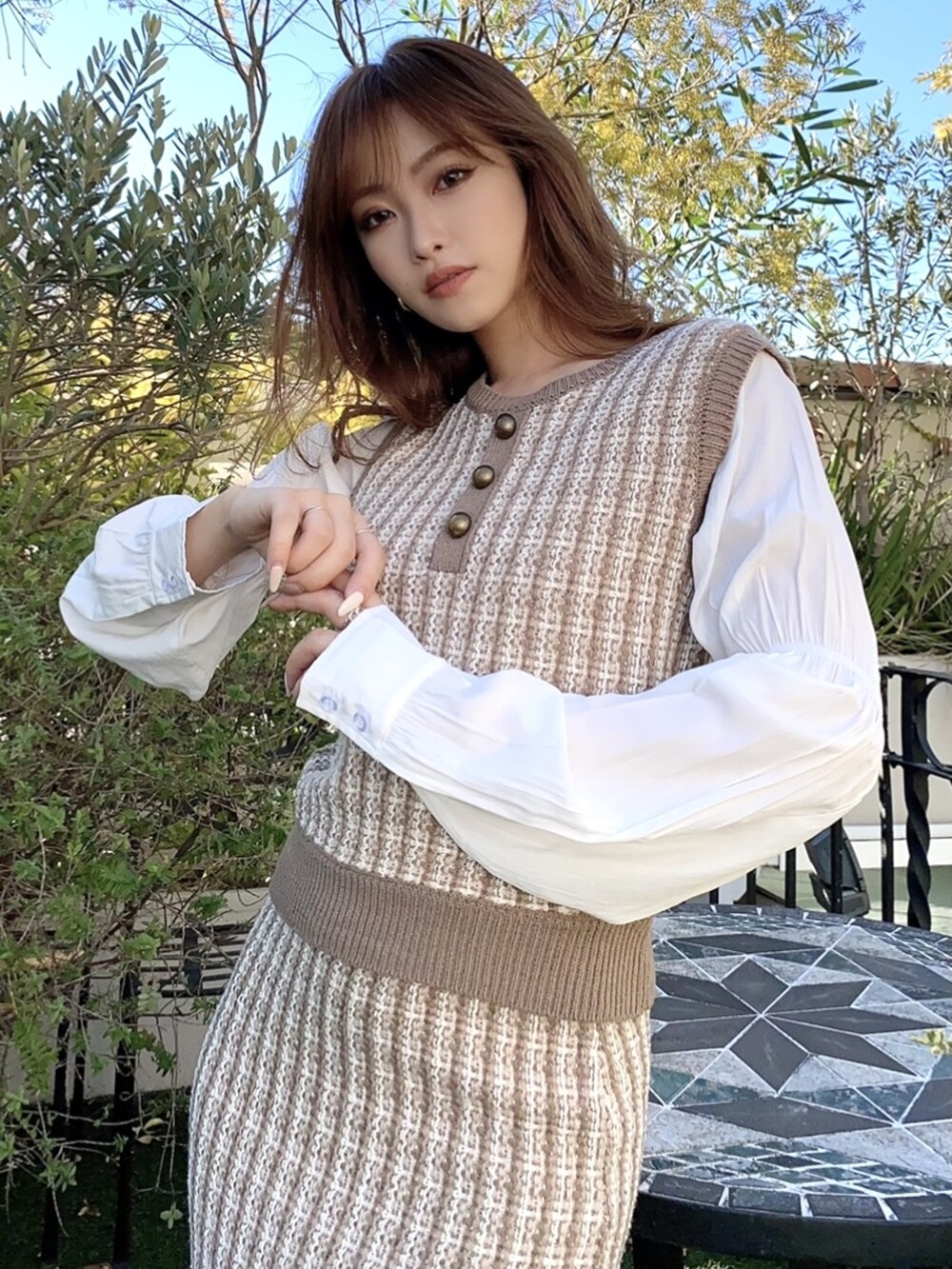 ベージュ系のその他アウター、ブラウン系のスカート、ベージュ系のパンプスを着用したレディースの冬コーディネートの2枚目の写真