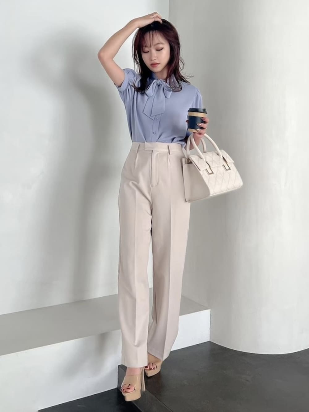 ホワイト系のハンドバッグ、ベージュ系のサンダル、ブルー系のシャツ/ブラウスを着用したレディースの春コーディネートの3枚目の写真