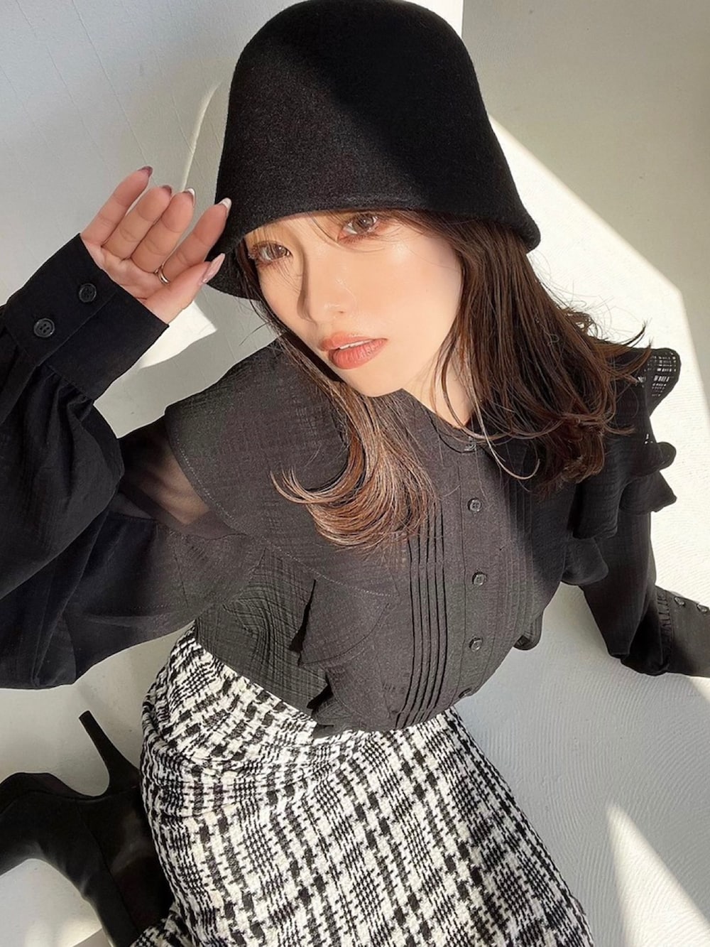 ブラック系のシャツ/ブラウス、ブラック系のスカート、ブラック系のブーツを着用したレディースの秋コーディネートの2枚目の写真