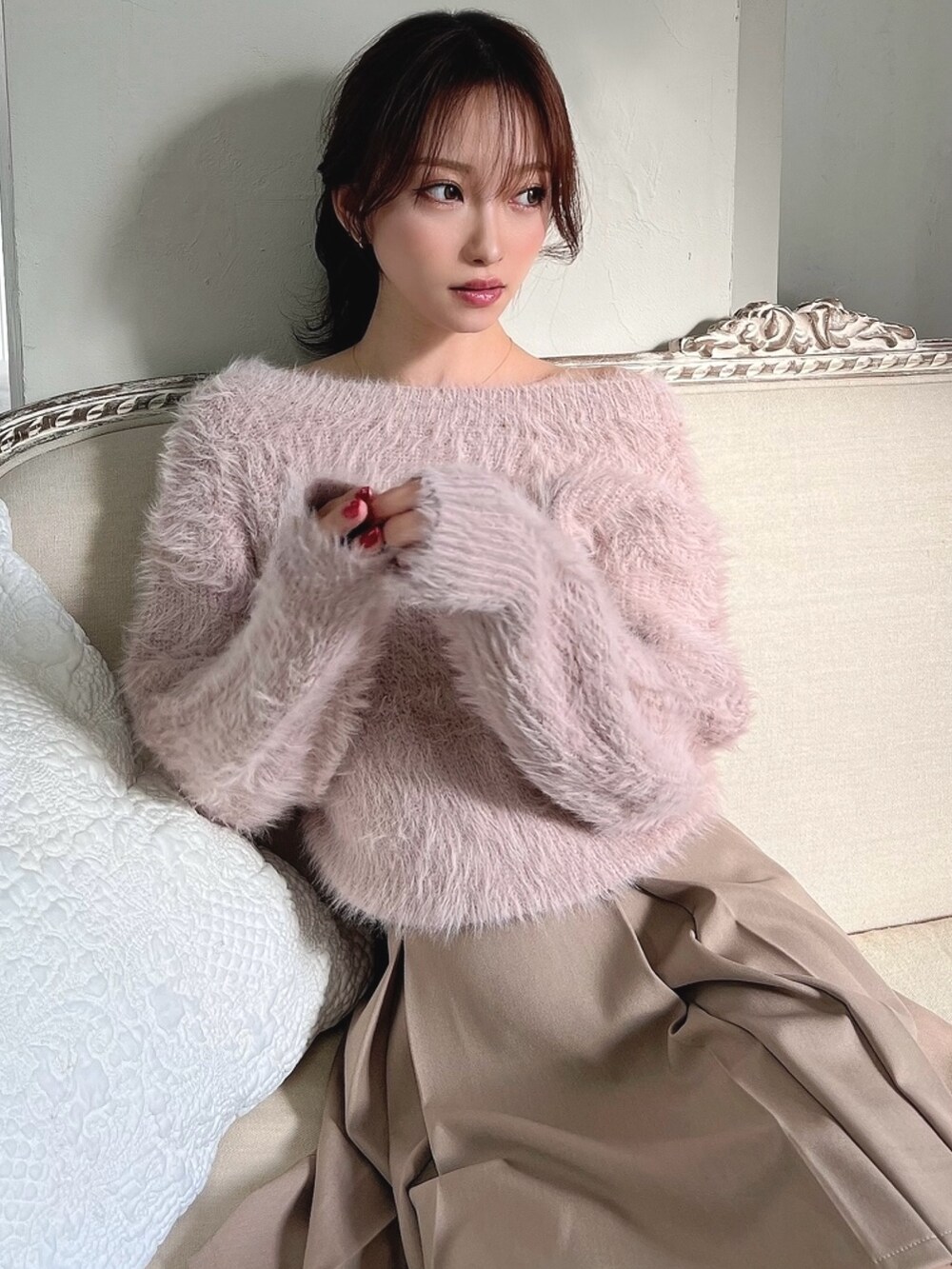 ピンク系のカーディガン/ボレロ、ベージュ系のスカート、ブラック系のブーツを着用したレディースの冬コーディネートの2枚目の写真