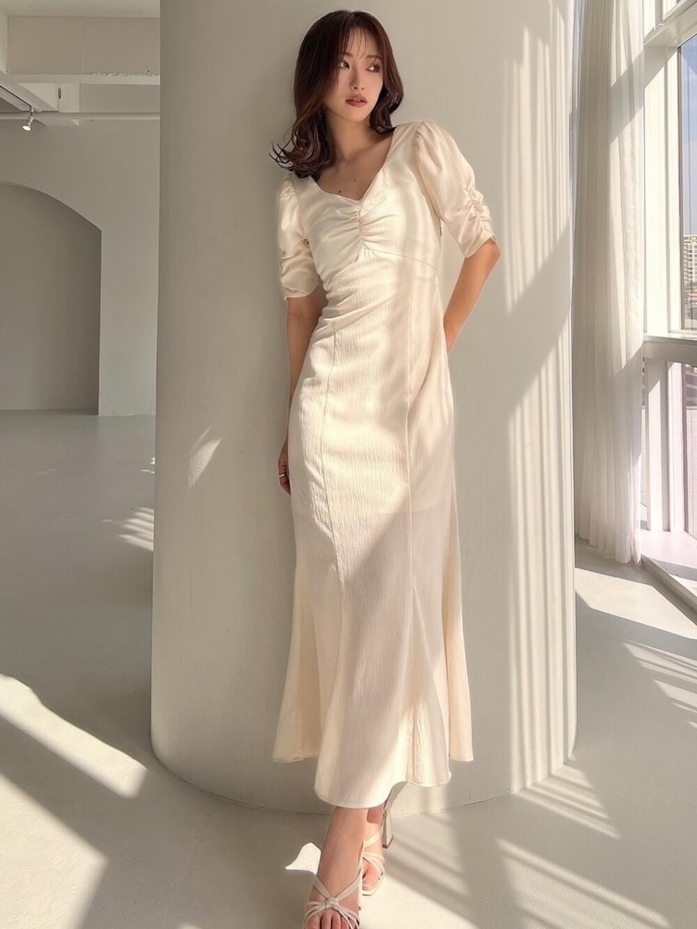 ホワイト系のワンピース、ホワイト系のサンダルを着用したレディースの春コーディネートの2枚目の写真