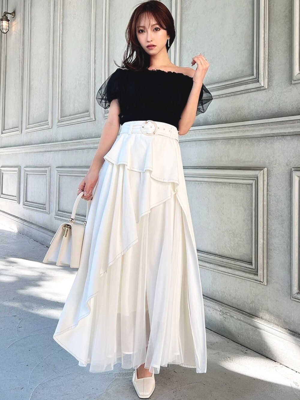 ホワイト系のパンプス、ホワイト系のデニムスカート、ブラック系のシャツ/ブラウスを着用したレディースの冬コーディネートの2枚目の写真