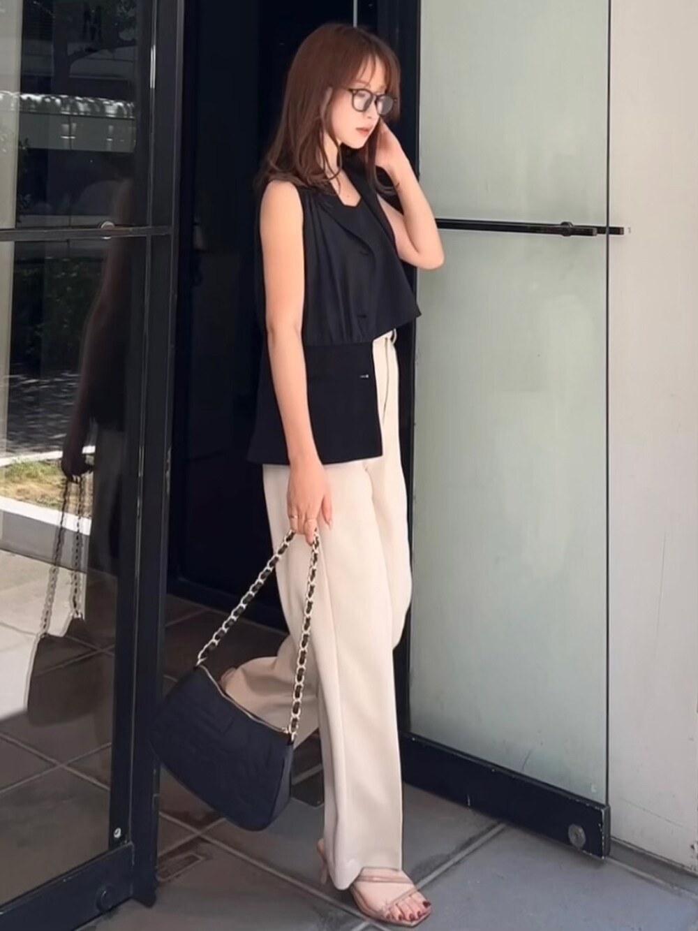 ブラック系のテーラードジャケット、ブラック系のキャミソール、ホワイト系のその他パンツを着用したレディースの夏コーディネートの2枚目の写真