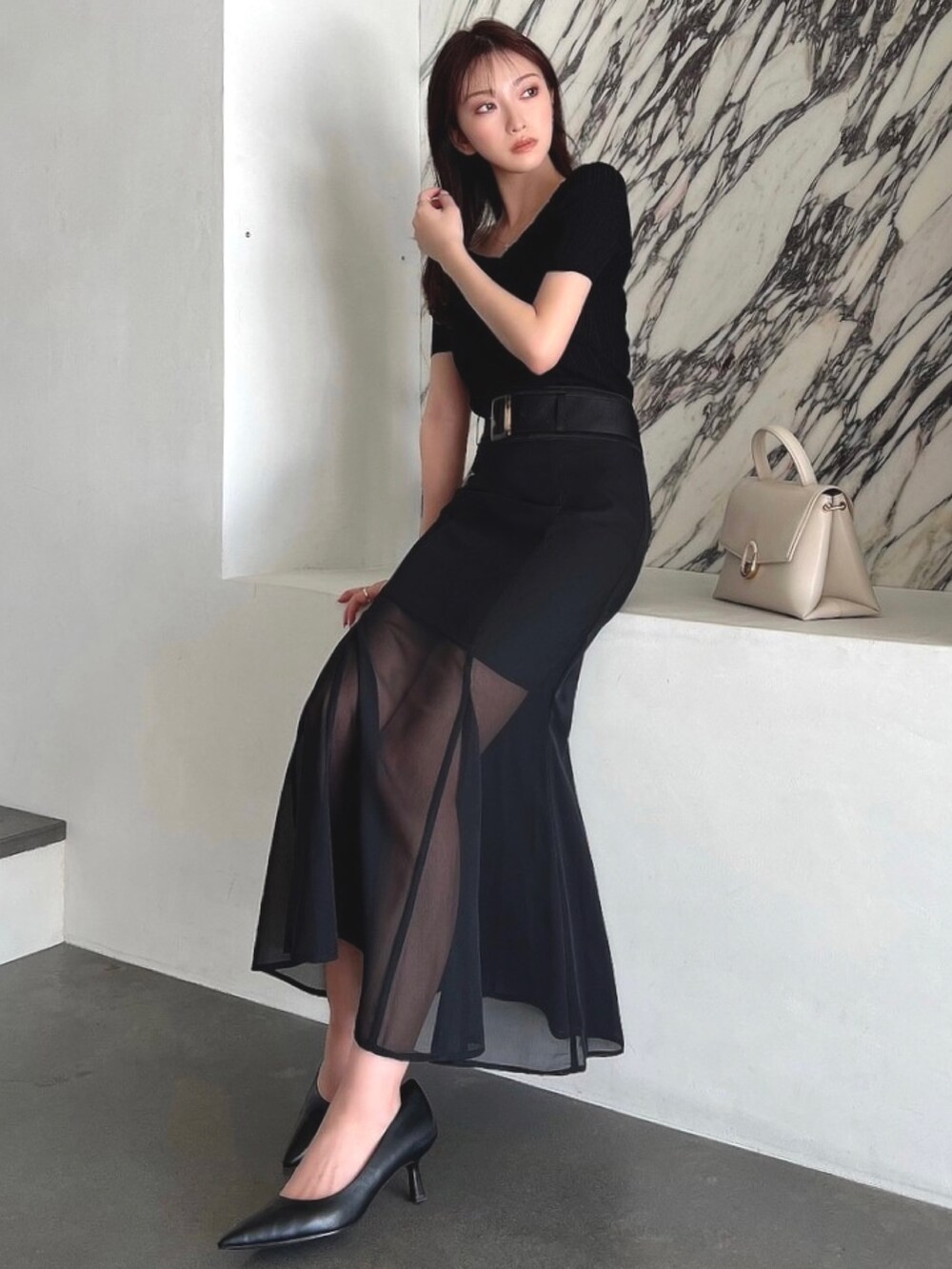 ブラック系のスカートを着用したレディースの春コーディネートの3枚目の写真