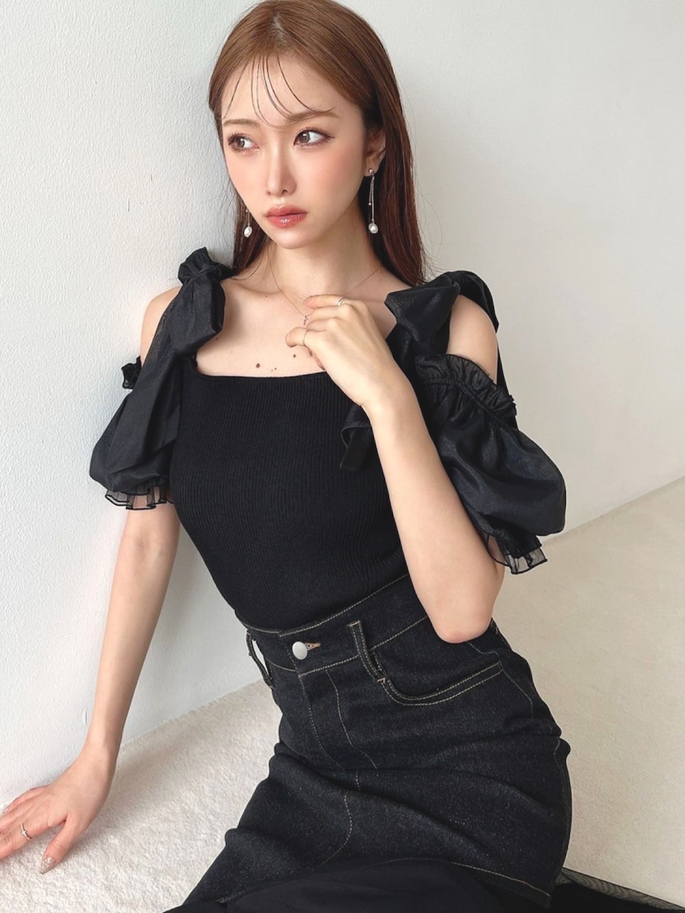 ブラック系のニット/セーター、ブラック系のスカート、ピンク系のハンドバッグを着用したレディースの夏コーディネートの4枚目の写真