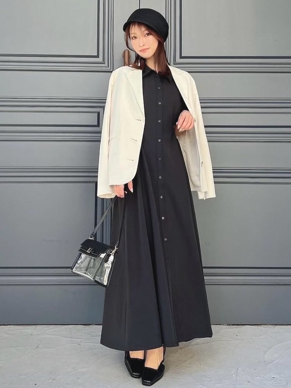 ホワイト系のテーラードジャケット、ブラック系のワンピース、ブラック系のハンドバッグを着用したレディースの春コーディネートの4枚目の写真