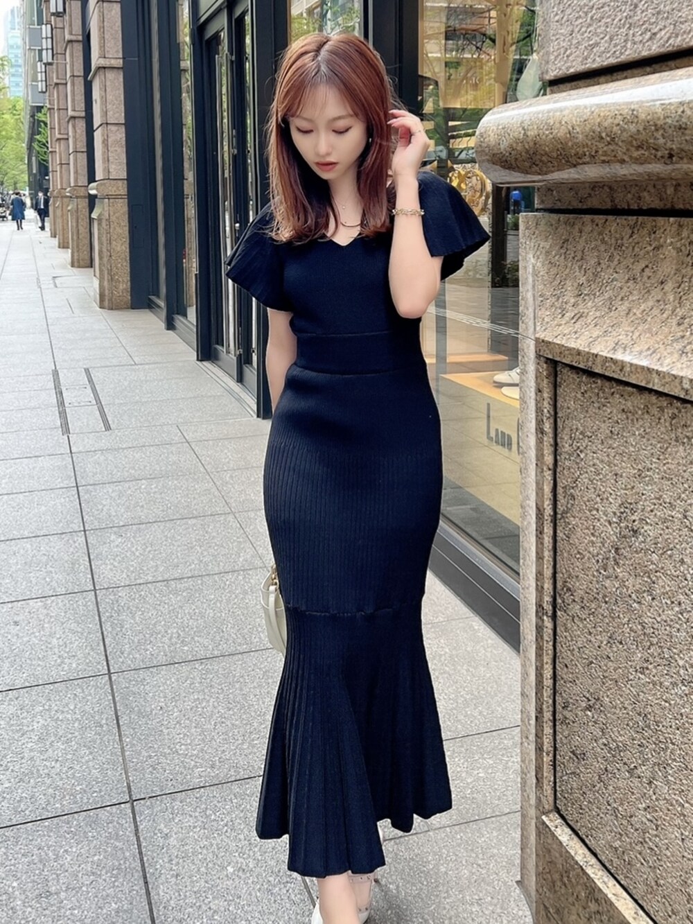 ブラック系のワンピースを着用したレディースの春コーディネートの2枚目の写真