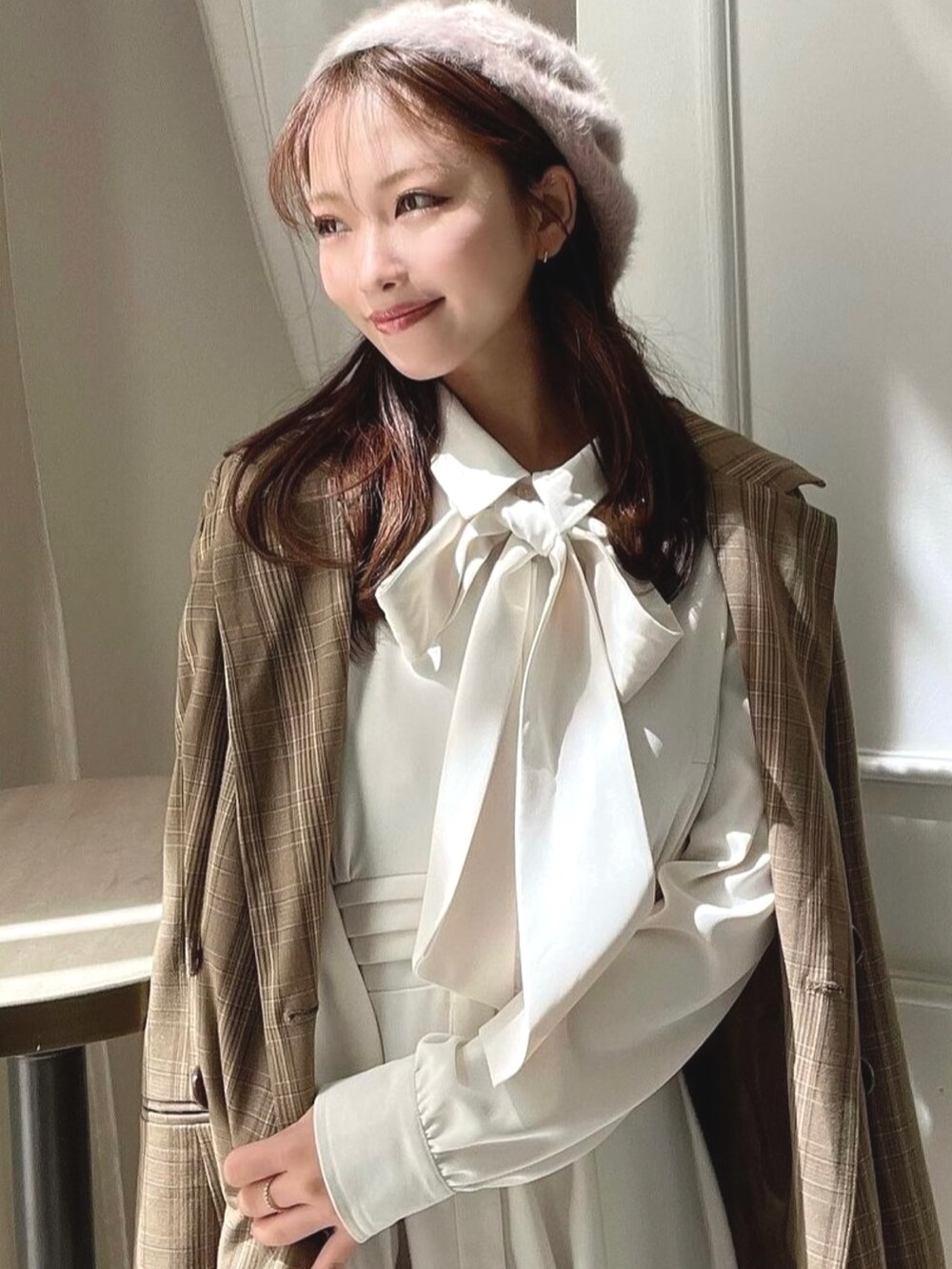 ホワイト系のシャツワンピース、ブラウン系のテーラードジャケット、ブラウン系のブーツを着用したレディースの秋コーディネートの3枚目の写真