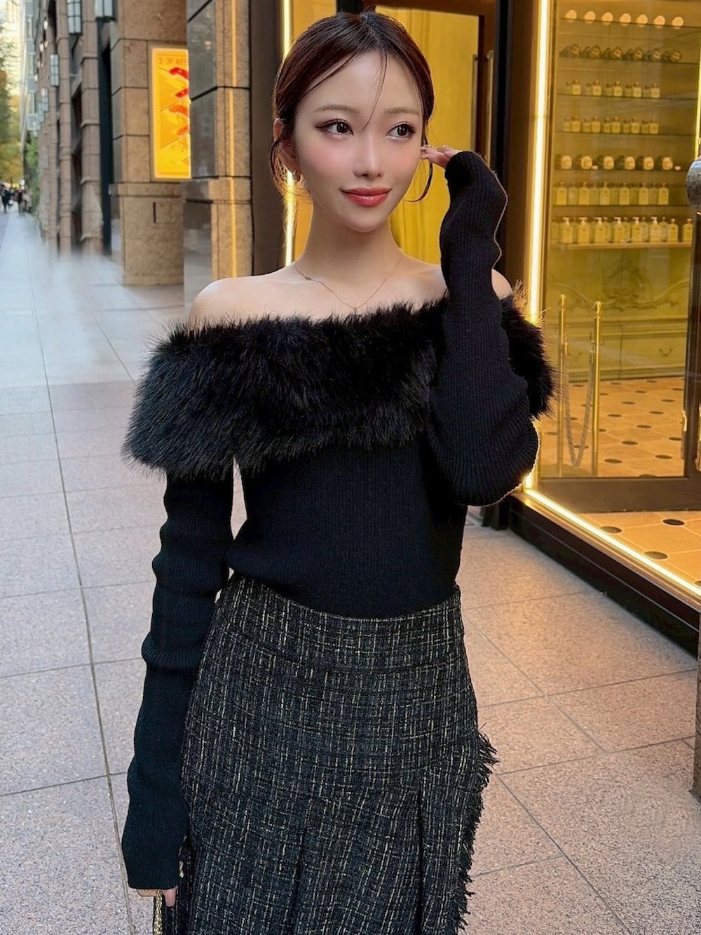 ブラック系のニット/セーター、ブラック系のスカート、ブラック系のハンドバッグを着用したレディースの冬コーディネートの4枚目の写真