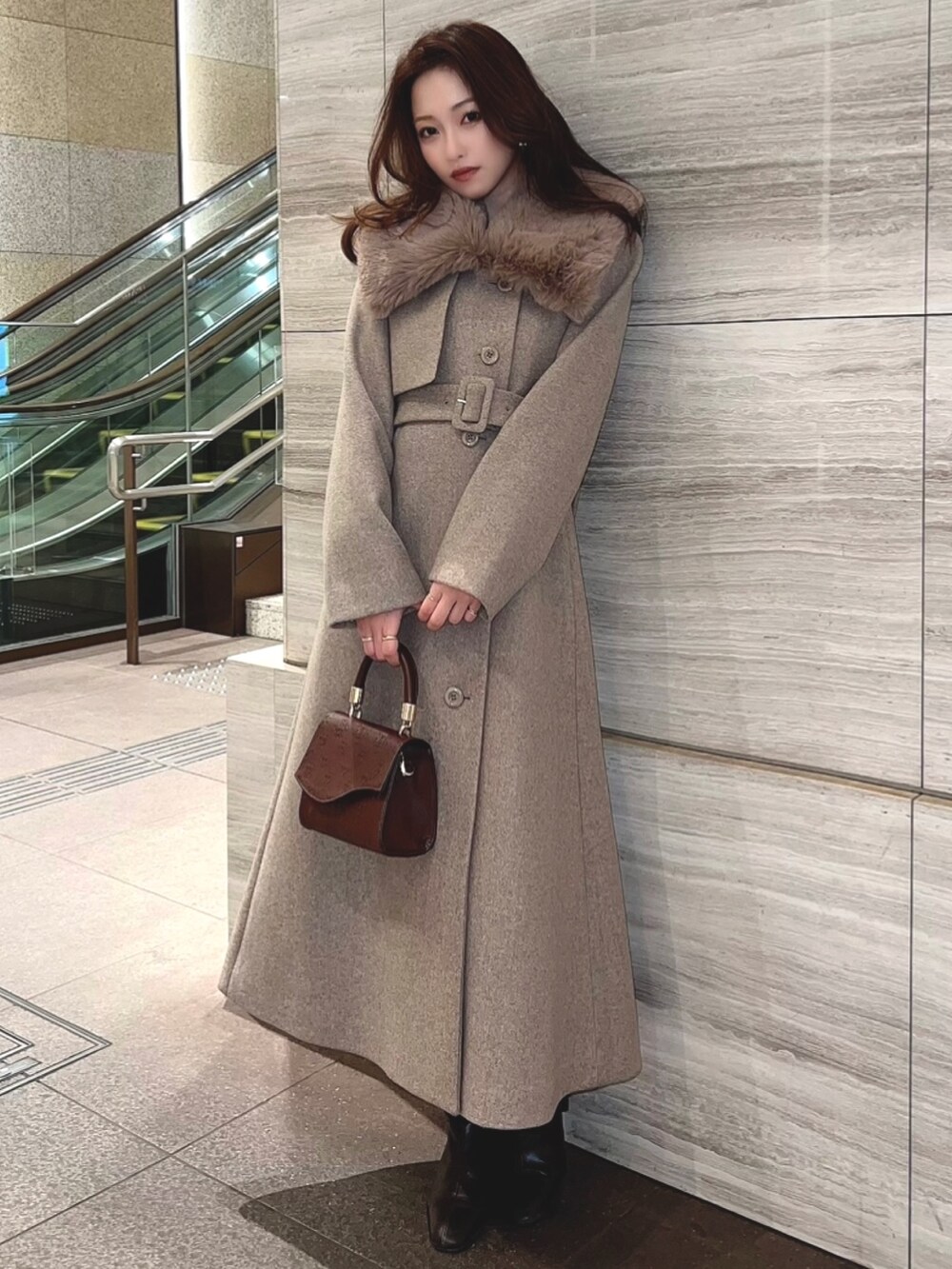 ブラウン系のその他アウター、ブラウン系のハンドバッグを着用したレディースの冬コーディネートの2枚目の写真