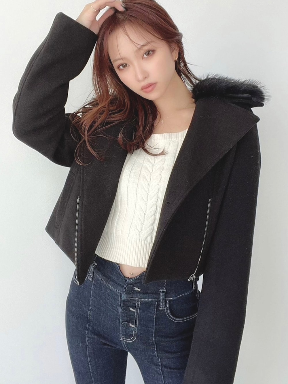 ブルー系のデニムパンツ、ホワイト系のニット/セーター、ブラック系のその他アウターを着用したレディースの秋コーディネートの3枚目の写真