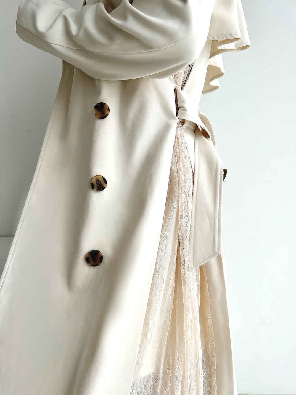 ブルー系のニット/セーター、ホワイト系のトレンチコート、ホワイト系のスカートを着用したレディースの冬コーディネートの3枚目の写真