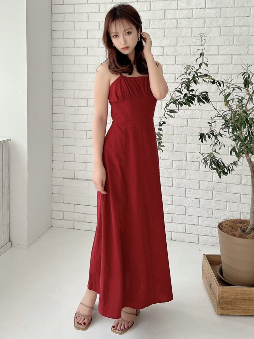 ピンク系のサンダル、レッド系のワンピースを着用したレディースの春コーディネートの2枚目の写真