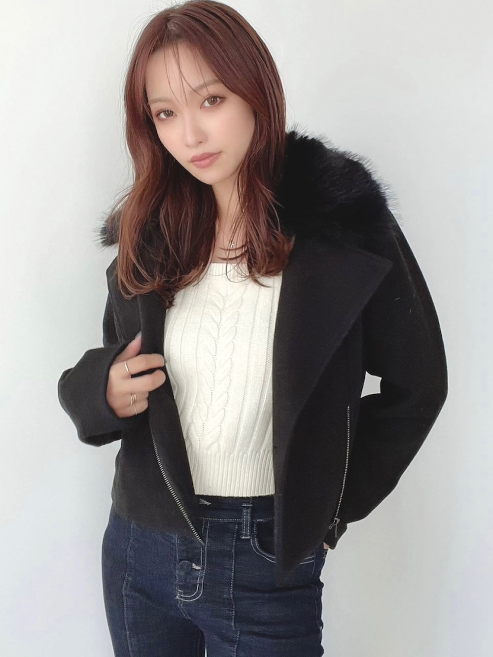 ブルー系のデニムパンツ、ホワイト系のニット/セーター、ブラック系のその他アウターを着用したレディースの秋コーディネートの4枚目の写真