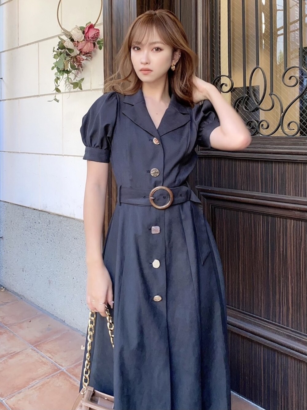 ブラック系のワンピース、ブラック系のパンプス、ブラウン系のショルダーバッグを着用したレディースの冬コーディネートの2枚目の写真