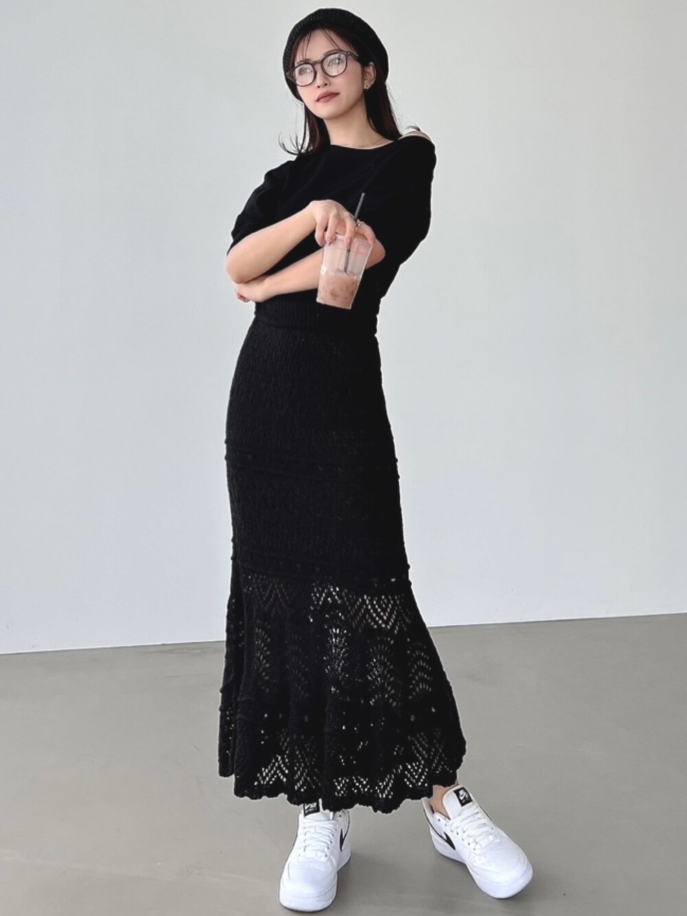 ブラック系のスウェット、ブラック系のスカートを着用したレディースの春コーディネートの2枚目の写真