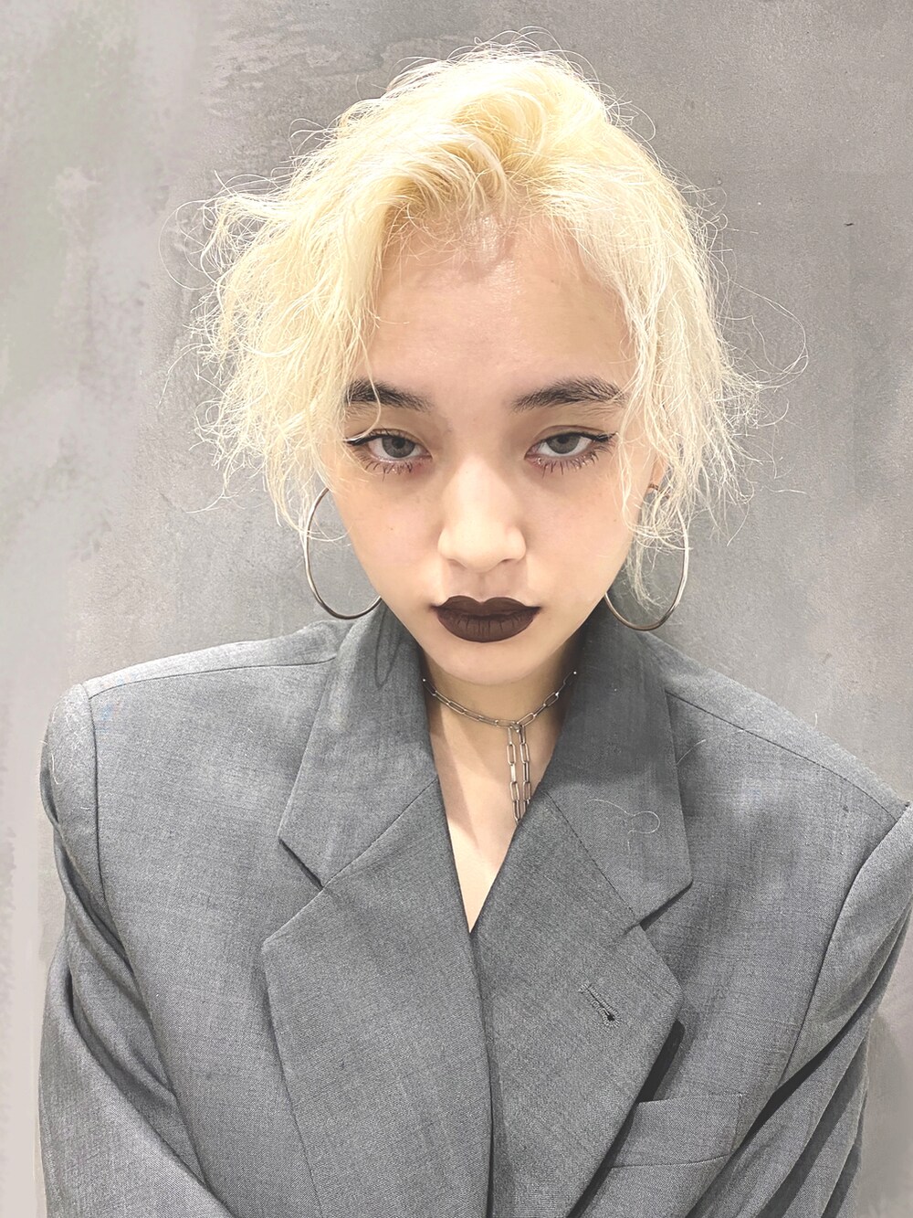 グレー系のトレンチコートを着用したレディースの秋コーディネートの2枚目の写真