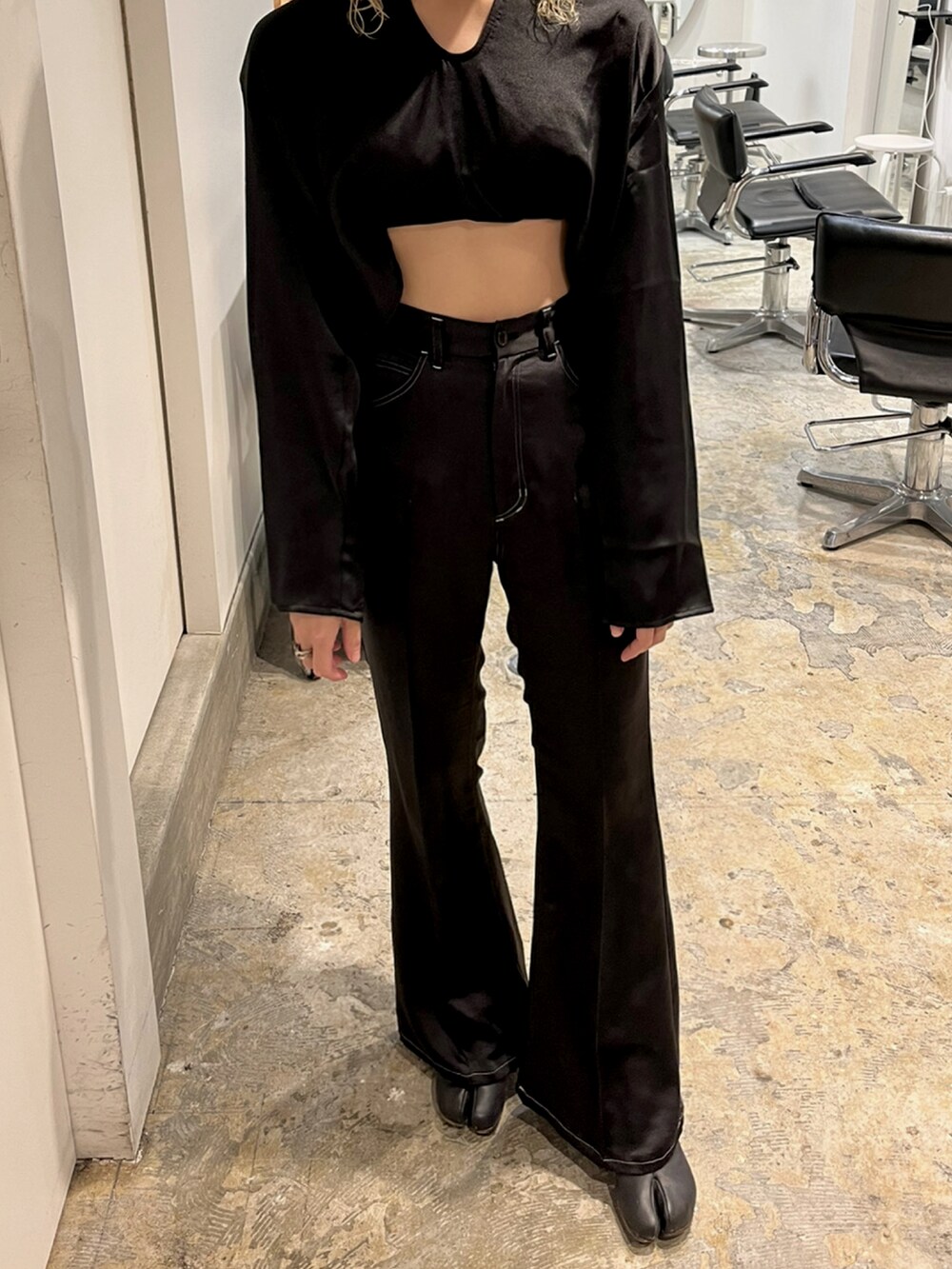 ブラック系のトップスを着用したレディースの秋コーディネートの2枚目の写真