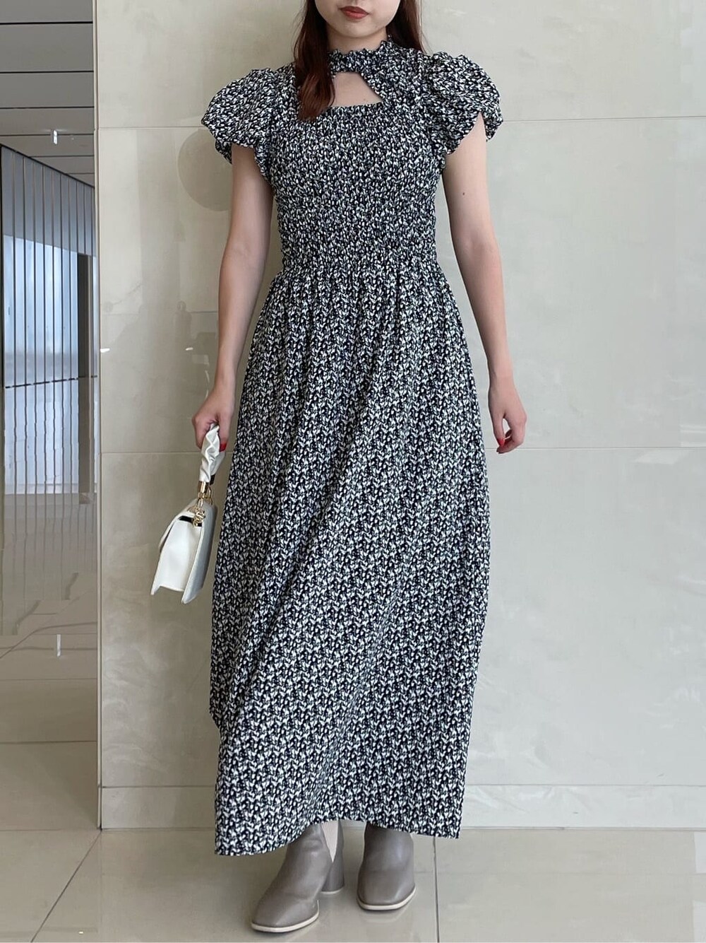 ブラック系のワンピース、ベージュ系のブーツを着用したレディースの夏コーディネートの3枚目の写真