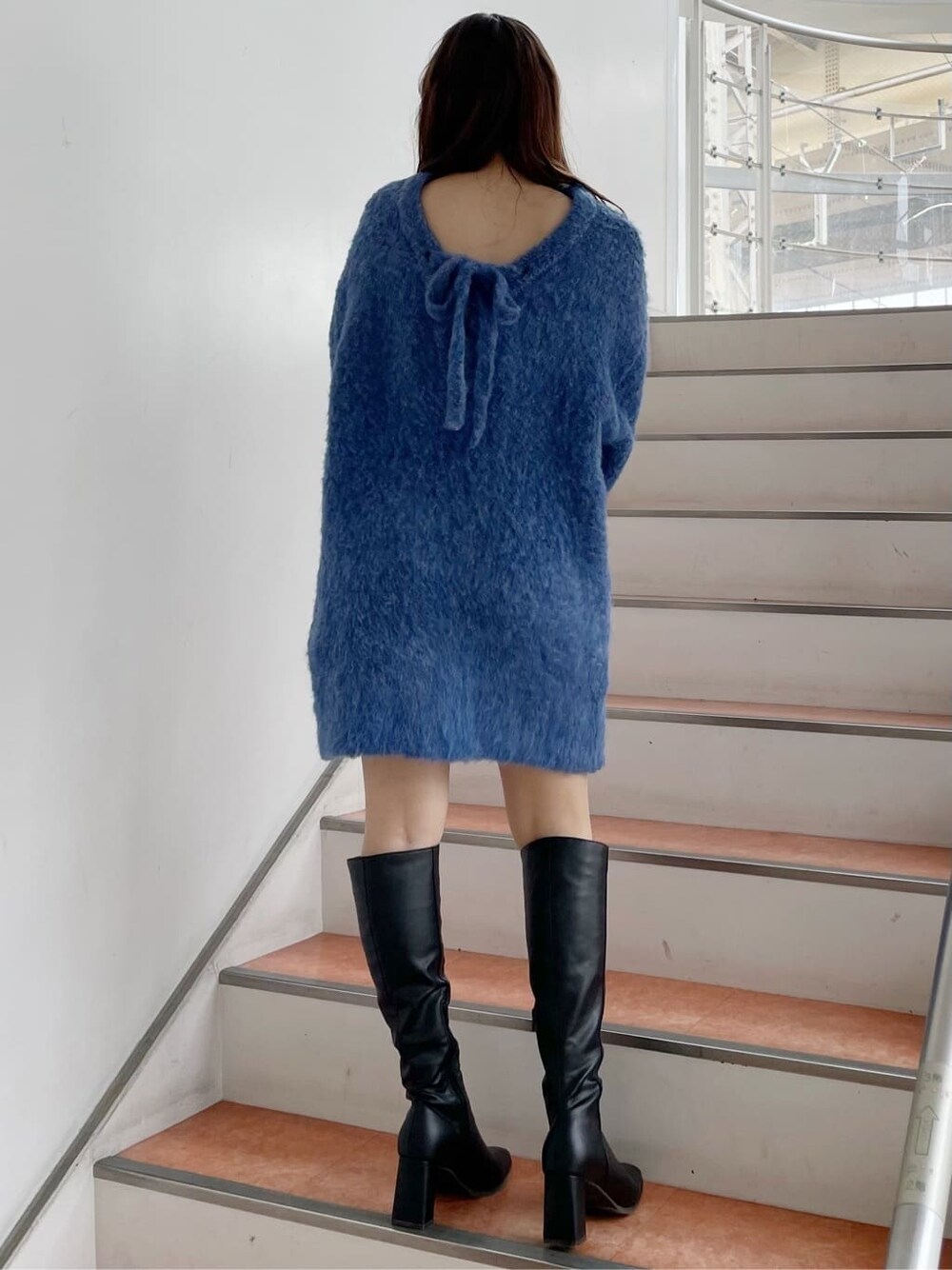 ブラック系のブーツ、ブルー系のニット/セーターを着用したレディースの秋コーディネートの2枚目の写真