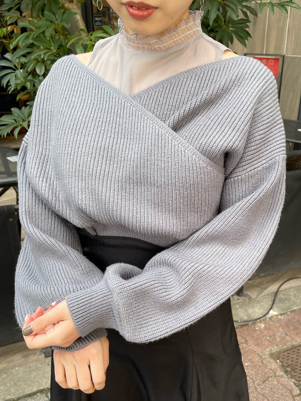 ブルー系のニット/セーター、ブラック系のスカート、ブラック系のブーツを着用したレディースの冬コーディネートの5枚目の写真