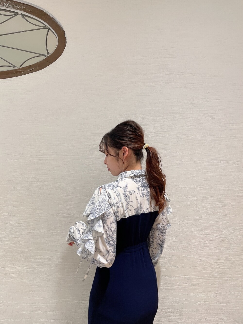 ブルー系のワンピース、ホワイト系のパンプスを着用したレディースの冬コーディネートの6枚目の写真