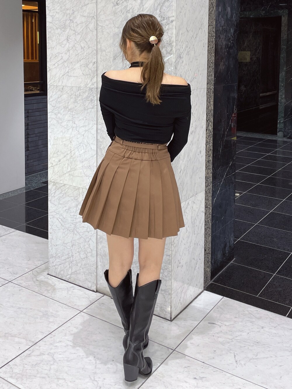 ブラック系のTシャツ/カットソー、ブラウン系のスカート、その他のブーツを着用したレディースの冬コーディネートの4枚目の写真