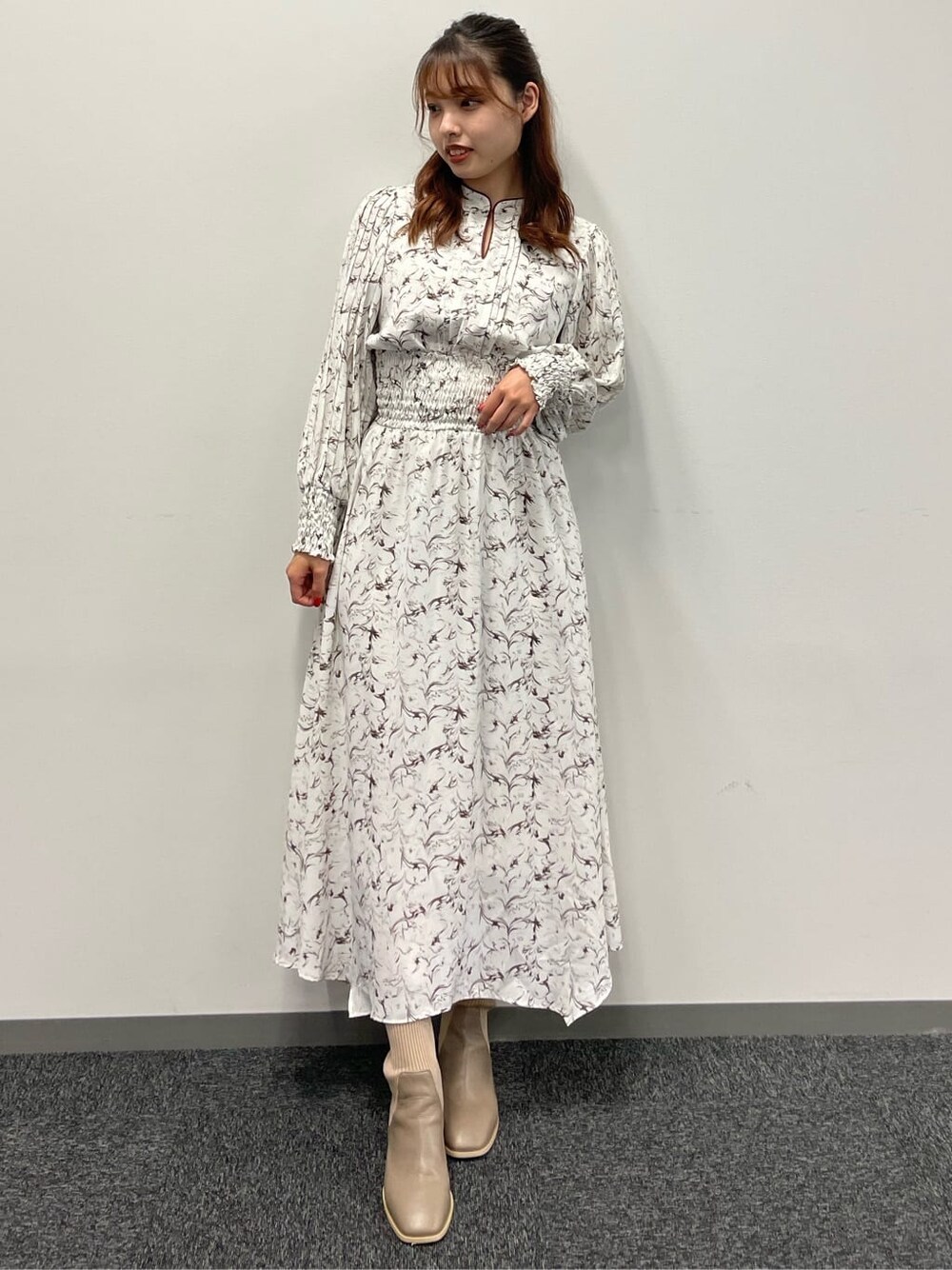 ホワイト系のワンピース、ベージュ系のブーツを着用したレディースの夏コーディネートの2枚目の写真