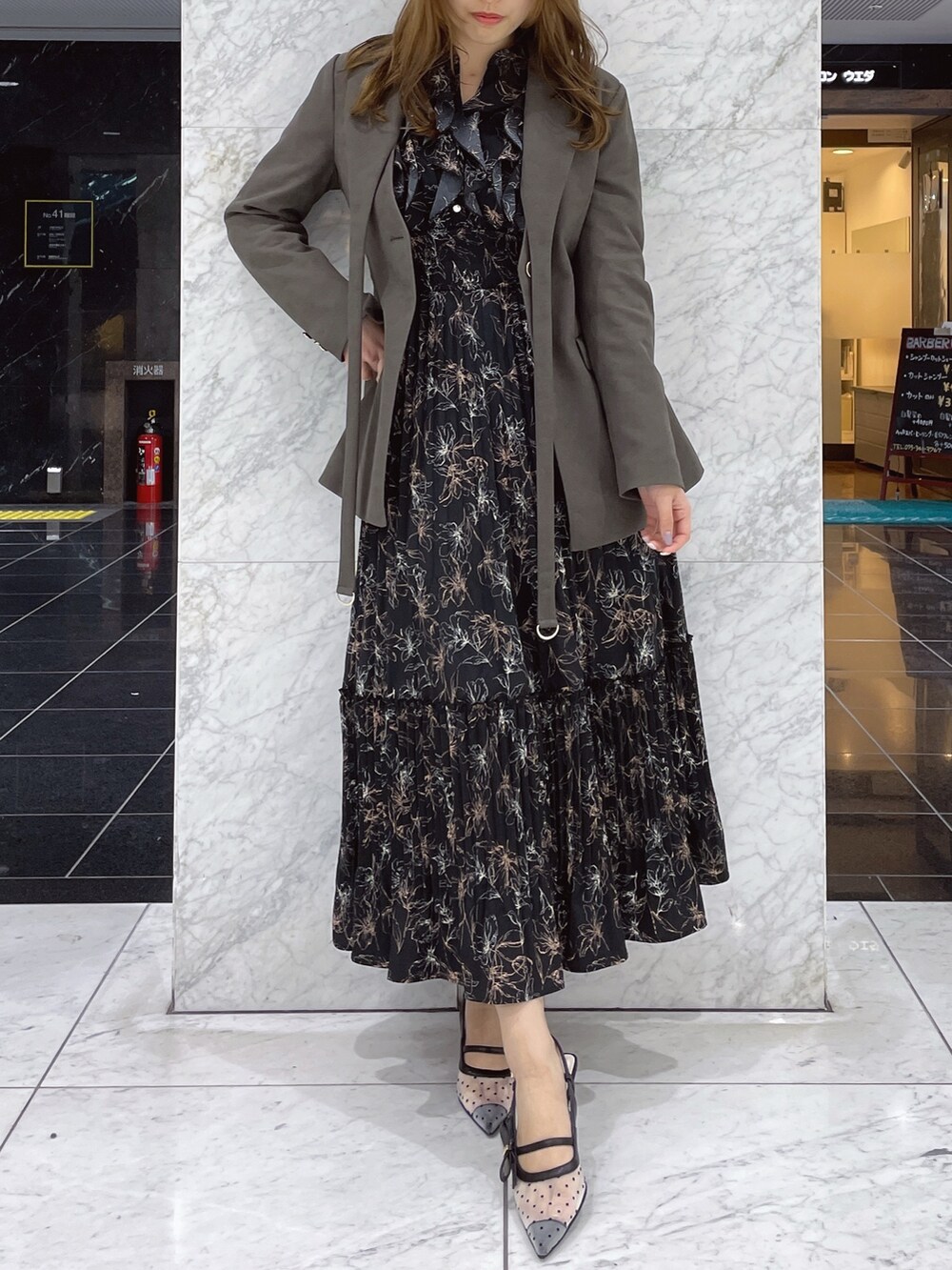 ブラック系のワンピース、ブラウン系のテーラードジャケット、その他のパンプスを着用したレディースの冬コーディネートの2枚目の写真