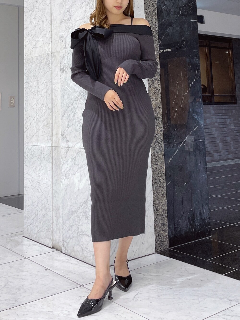 グレー系のワンピース、ブラック系のパンプスを着用したレディースの秋コーディネートの2枚目の写真