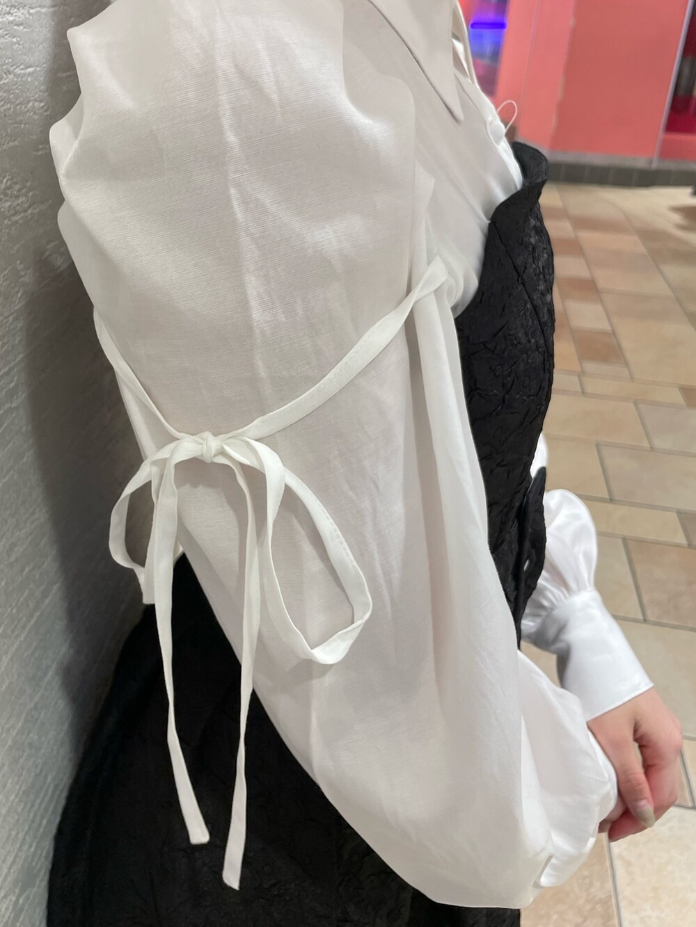 ブラック系のワンピース、ホワイト系のパンプスを着用したレディースの春コーディネートの6枚目の写真