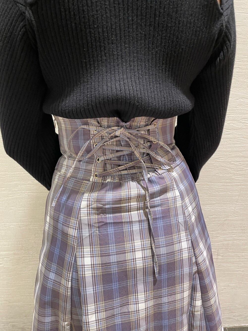 ブラック系のニット/セーター、パープル系のスカート、ベージュ系のブーツを着用したレディースの冬コーディネートの9枚目の写真